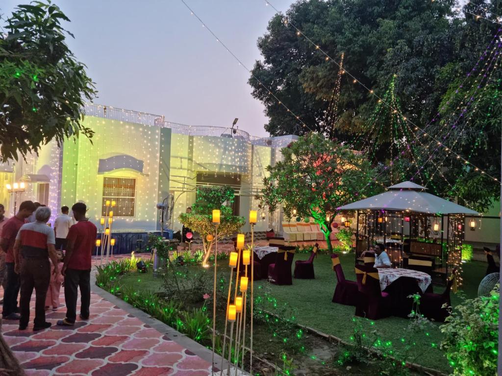 a group of people standing in a garden with lights at Harsh Villa in Prayagraj