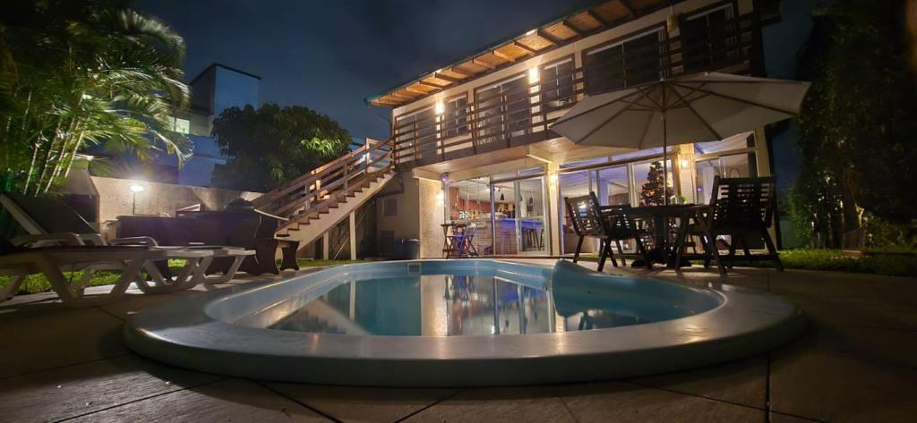 una piscina frente a una casa por la noche en Pousada Casa Campeche - Floripa, en Florianópolis