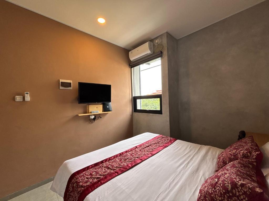 una camera con letto e TV a parete di The Cluster Harris a Cimahi