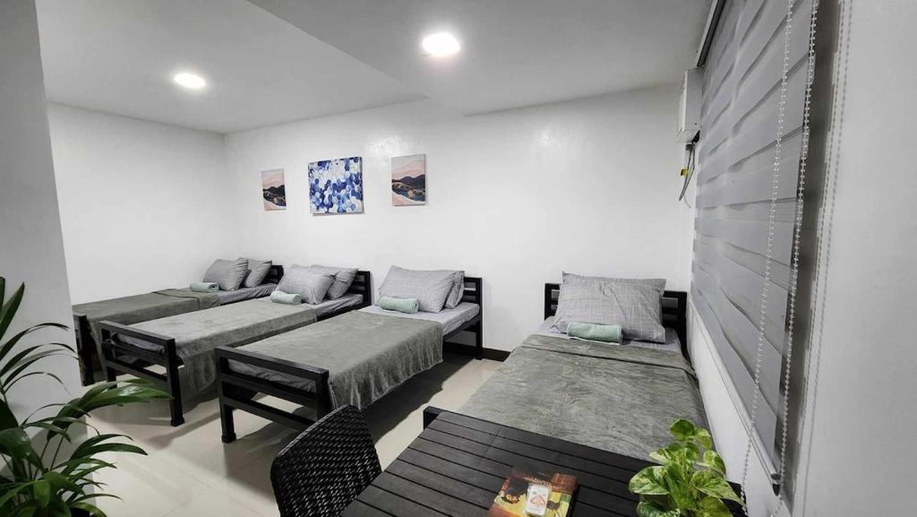 a room with two beds and a couch at LMS Guest House in Iloilo City