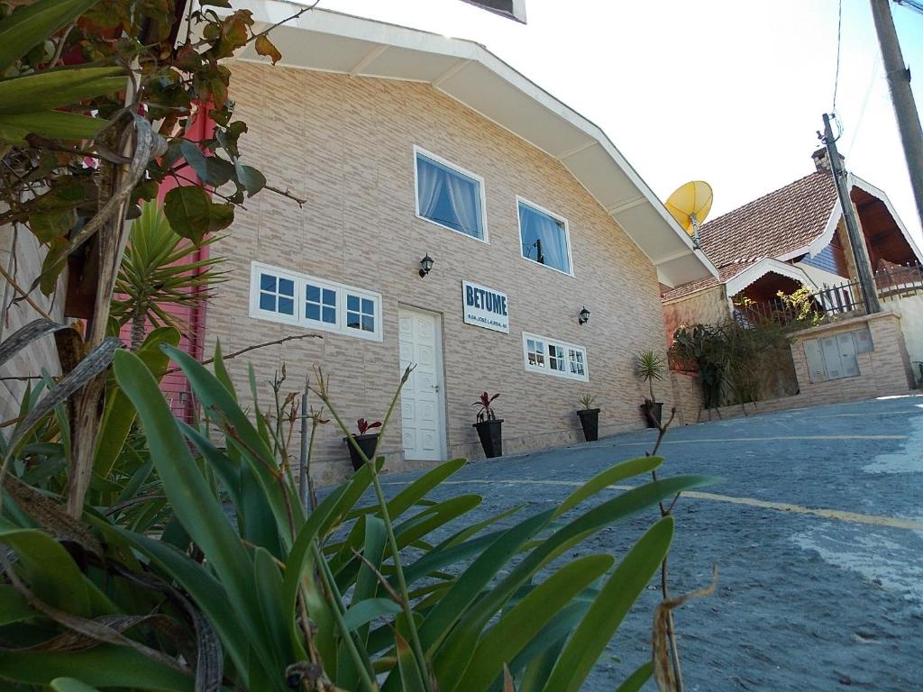 a house with a driveway in front of it at Betume in Campos do Jordão