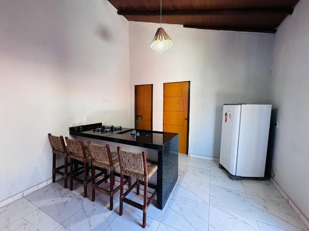 Vila Limeira في بورتو سيغورو: مطبخ مع كونتر اسود وثلاجة