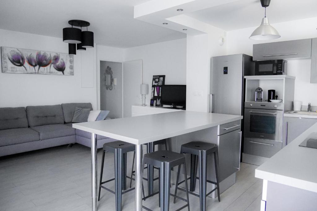 une cuisine avec une table et des tabourets dans une pièce dans l'établissement Sporting House, à Toulouse