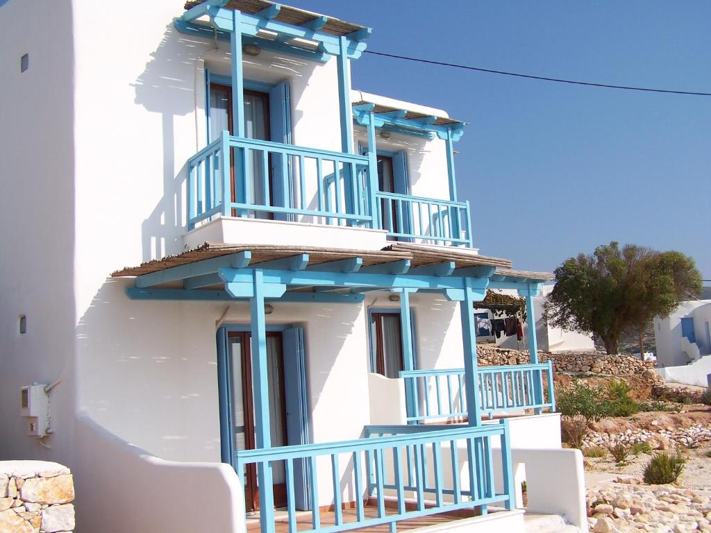 a white building with blue balconies on it at Asterias House in Donoussa