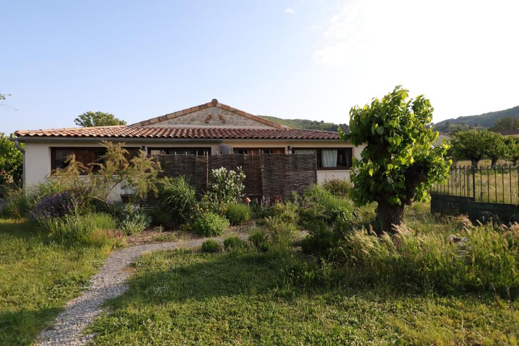 una casa con una valla delante de un patio en La Gourmandine -Gîtes, en Courry
