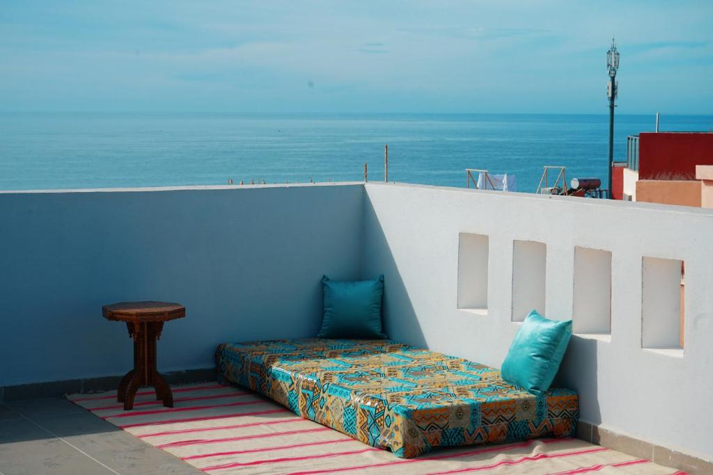 ein Bett auf der Seite einer Wand in der Unterkunft Perla House in Imsouane