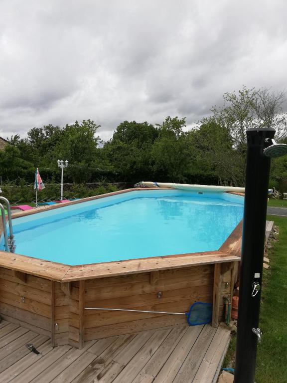 une grande piscine avec une terrasse en bois dans l'établissement Gîte chezmadlou, à Colondannes