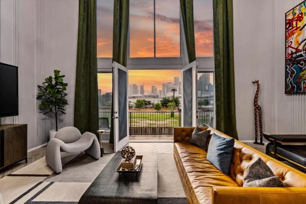 a living room with a couch and a large window at City Views Apartment - Near Minute Maid Park & Toyota Center in Houston