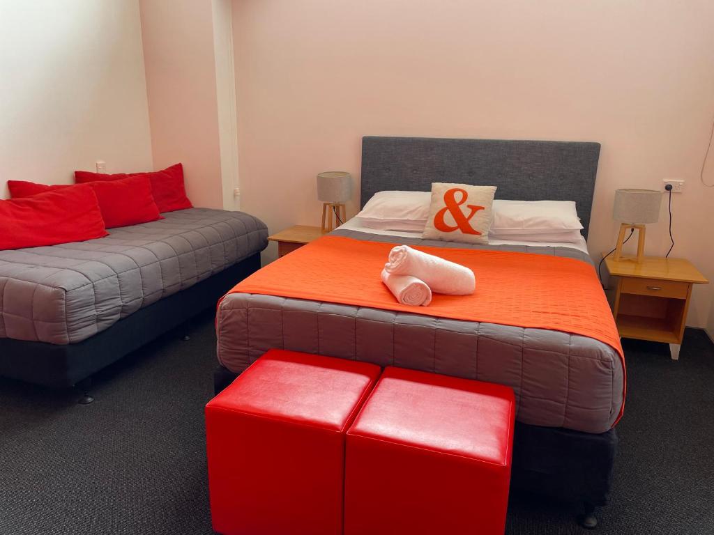 a room with two beds with red pillows at YHA Nelson in Nelson