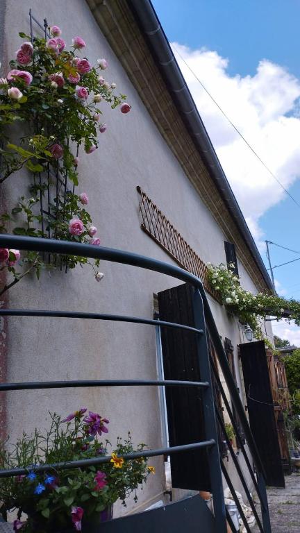 une maison avec des fleurs sur le côté dans l'établissement Maison charmante à Cadillac, à Cadillac