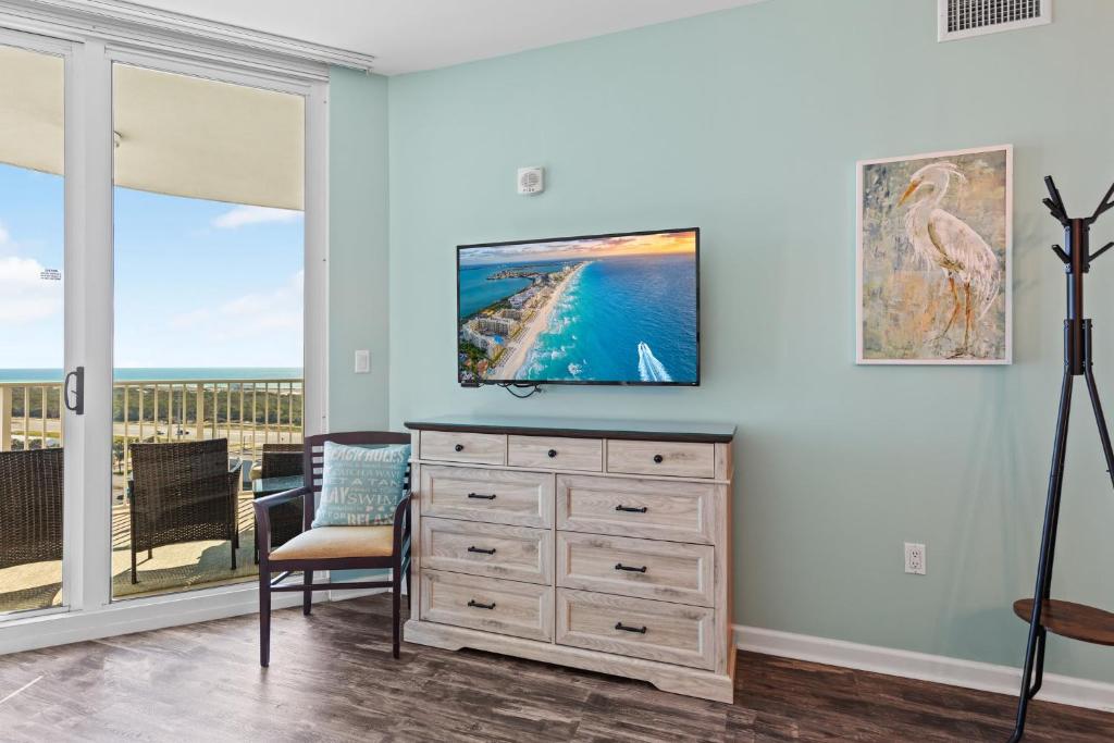 a living room with a television on a dresser at 5 Star Resort 11th Fl Stunning Sunrise 2BR 2BA King Suite,Pools ,Shuttle or Walk to Beach in Destin