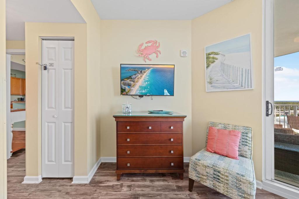 a living room with a dresser and a chair at 5 Star Resort 11th Fl Stunning Sunrise 2BR 2BA King Suite,Pools ,Shuttle or Walk to Beach in Destin