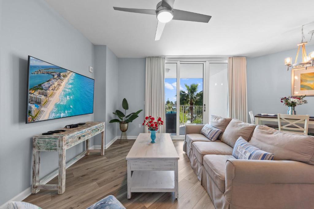 a living room with a couch and a tv at Palms Resort 2 BR King Suite Poolside Shuttle in Destin