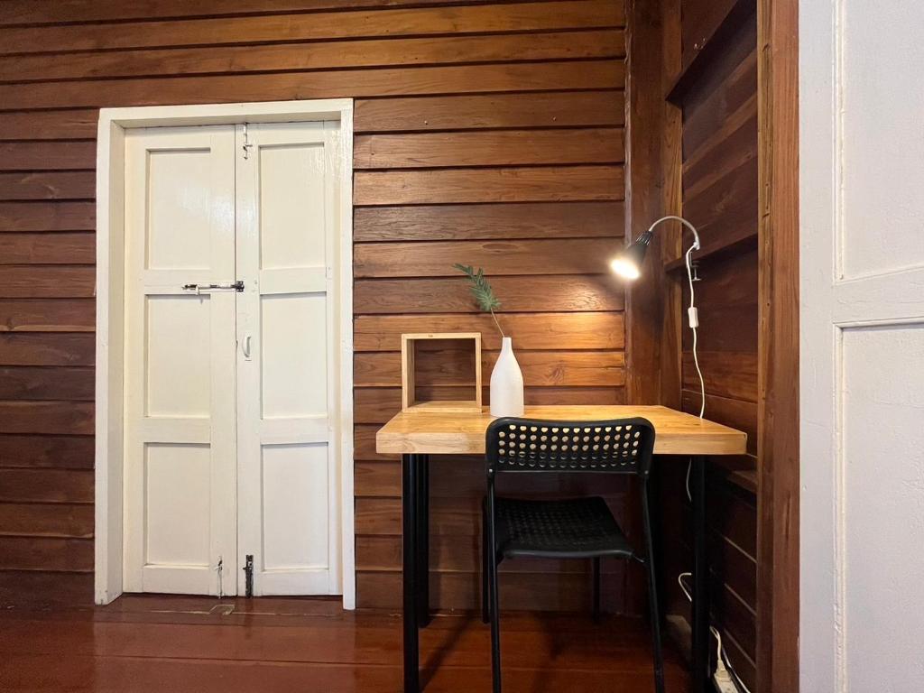 a room with a table and a chair and a door at Once in Lampang Guesthouse in Lampang
