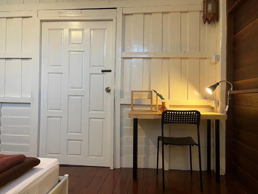 a room with a desk and a door and a chair at Once in Lampang Guesthouse in Lampang