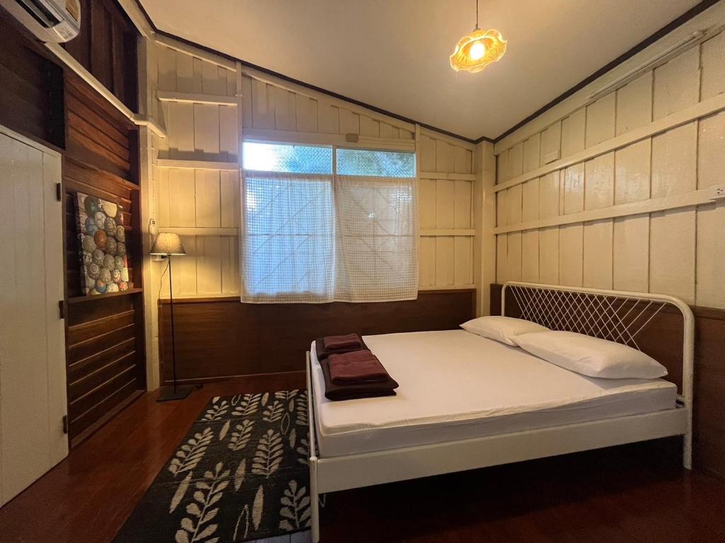 a small bedroom with a bed with a window at Once in Lampang Guesthouse in Lampang