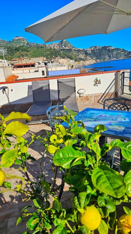 a patio with a table and chairs and a boat at Panoramic Terrace Room in Giardini Naxos