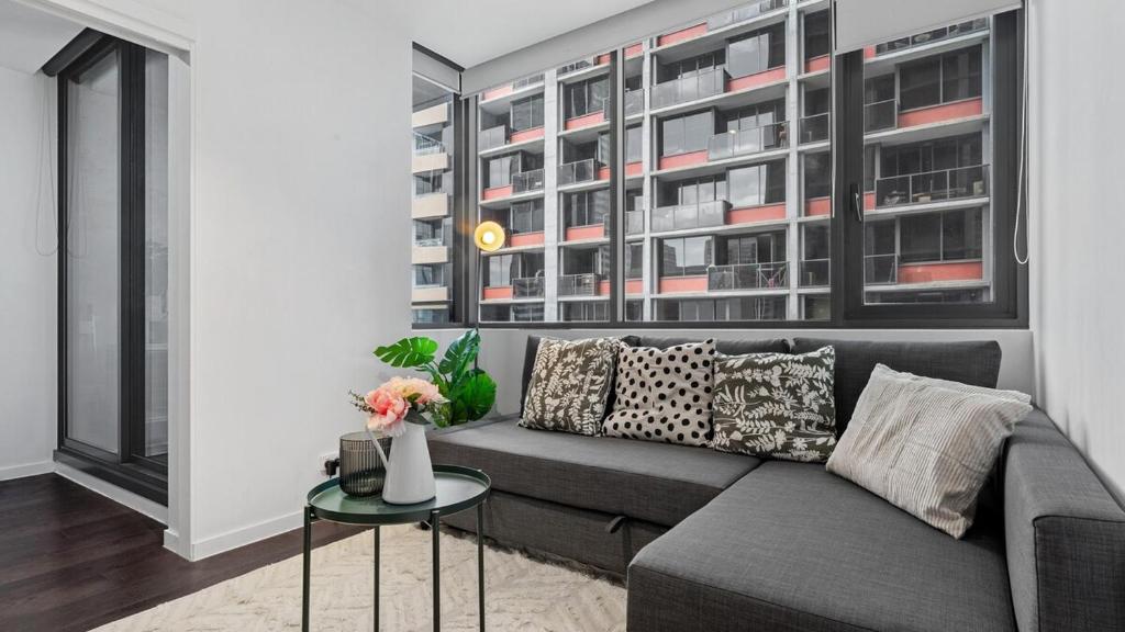 un soggiorno con un divano e un tavolo di The Downtown Nest a Melbourne