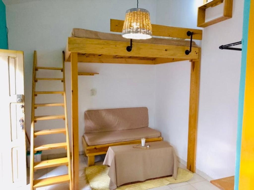 ein Schlafzimmer mit einem Etagenbett mit einem Stuhl und einem Tisch in der Unterkunft Casa Copal in San Cristóbal de las Casas