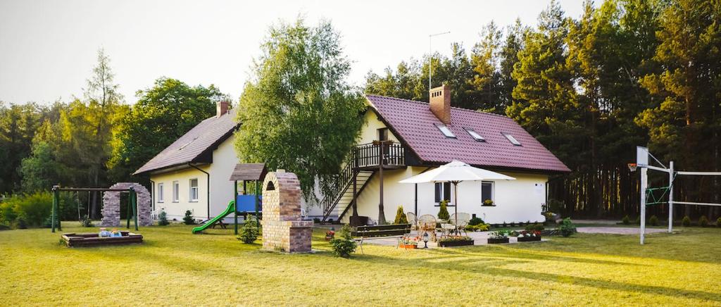 uma casa com um parque infantil no quintal em Bednarzówka em Nowy Tomyśl