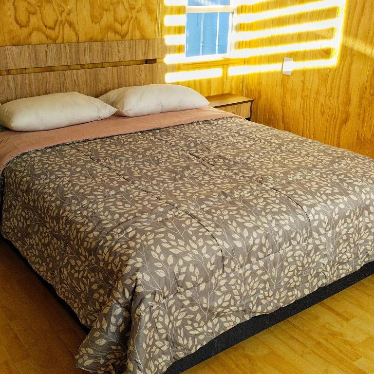a large bed in a bedroom with a wooden floor at Petrohue I in Valdivia