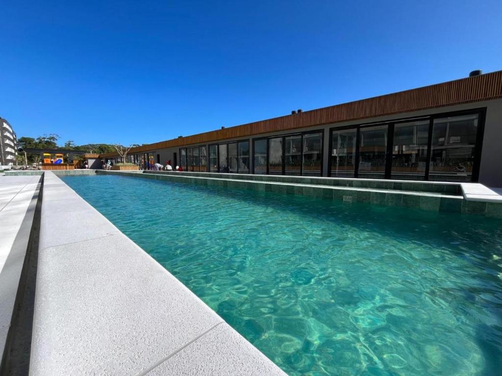 a large swimming pool in front of a building at Loft em Xangri-Lá com piscina aquecida in Xangri-lá