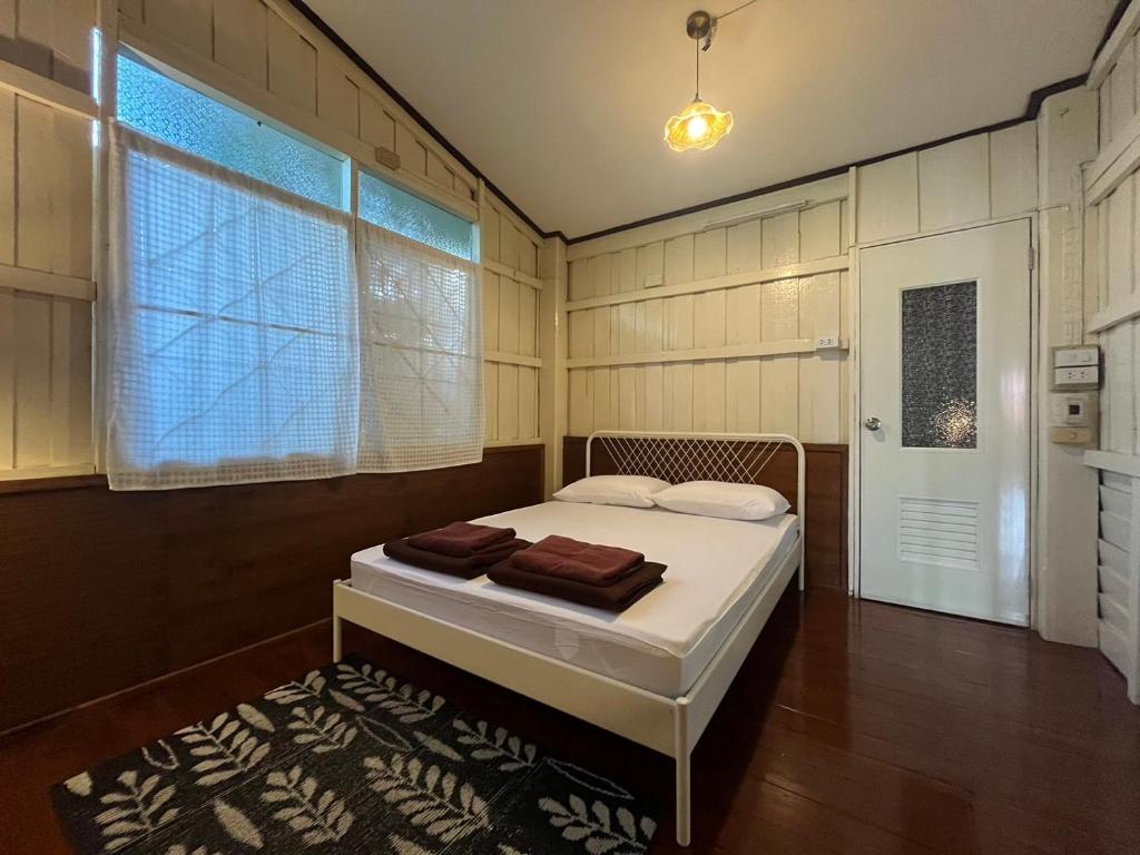 a bedroom with a bed in a room with a window at Once in Lampang Guesthouse in Lampang