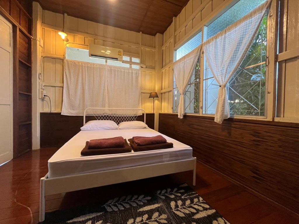 a bedroom with a bed in a room with a window at Once in Lampang Guesthouse in Lampang