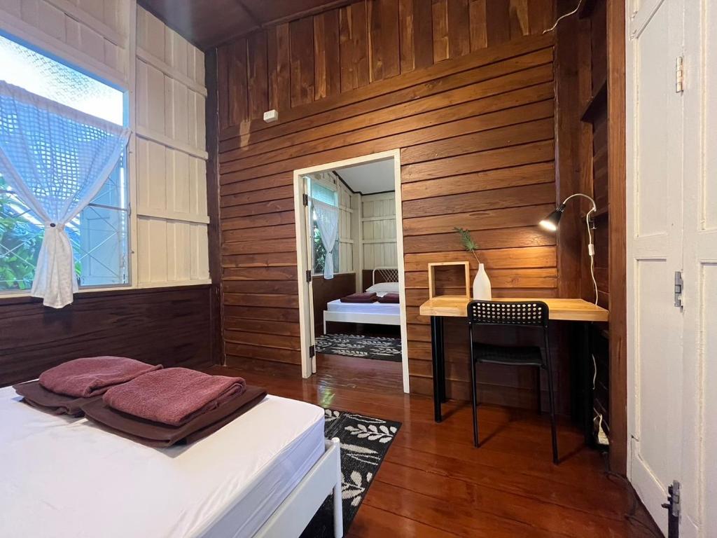 a bedroom with a bed and a desk and a mirror at Once in Lampang Guesthouse in Lampang