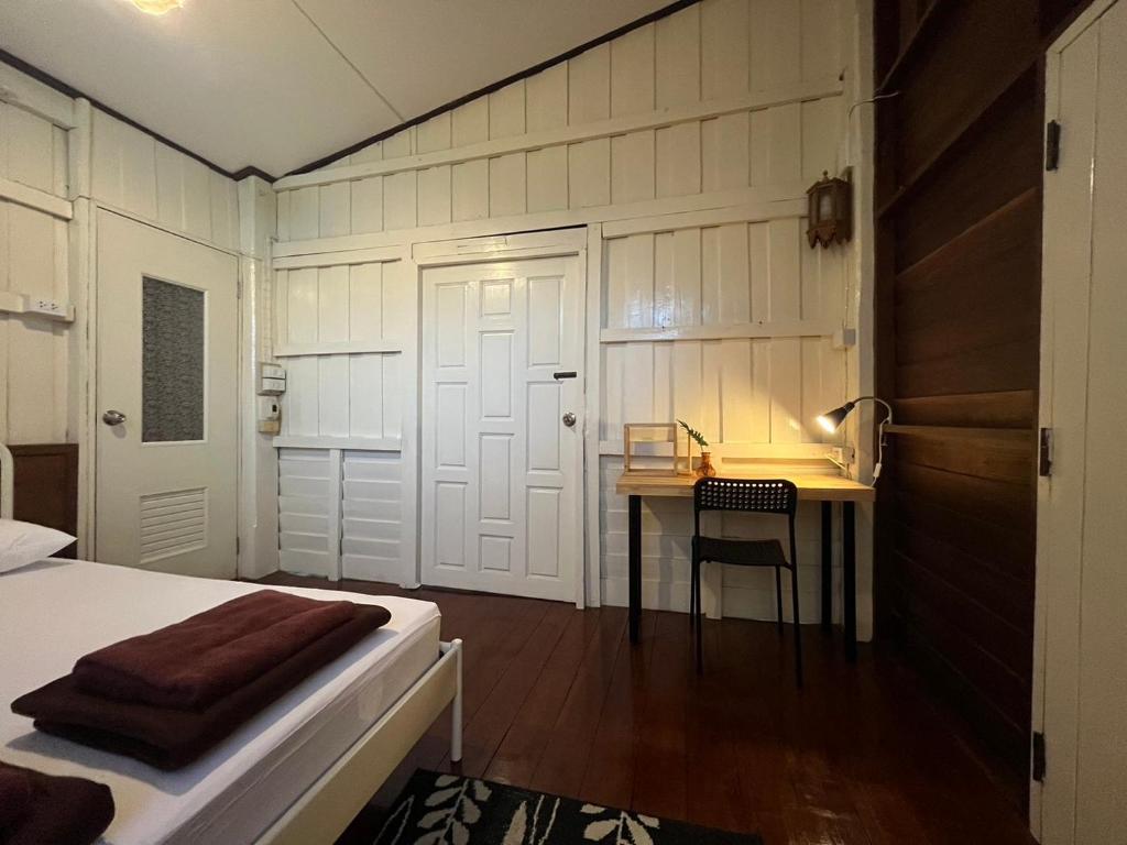 a bedroom with a desk and a bed and a table at Once in Lampang Guesthouse in Lampang