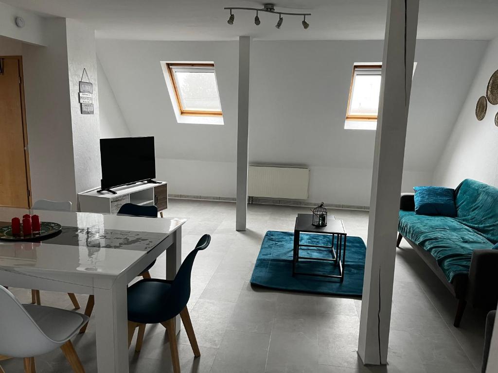 a living room with a table and a couch at Appartement de l angle Im Winkel in Oberbetschdorf
