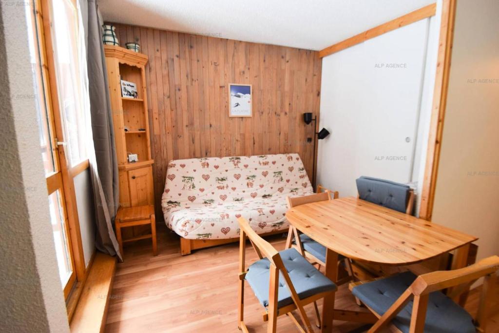 Cette petite chambre comprend une table et un canapé. dans l'établissement Résidence Les Soldanelles - Studio divisible 4 pers - LES SOLDANELLES - PLAGNE VILLAGES MAE-5944, à Aime La Plagne