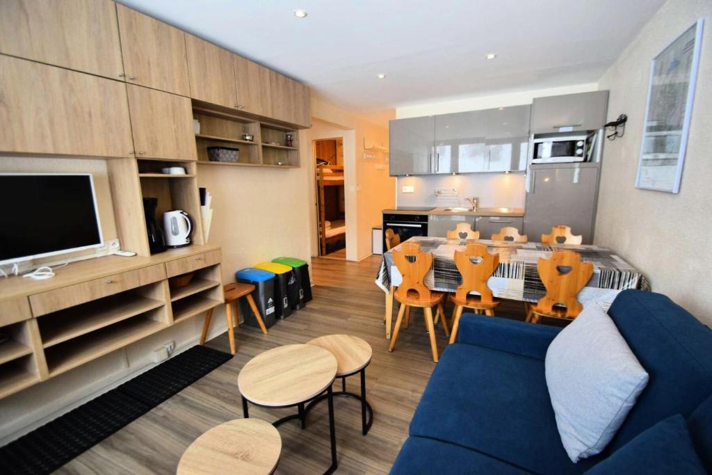 un salon avec un canapé bleu et une salle à manger dans l'établissement Résidence Le France - 3 pièces 6/7 pers - LE FRANCE - PLAGNE CENTRE MAE-9174, à Aime La Plagne