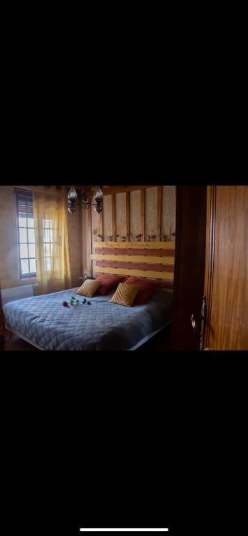 une chambre avec un lit avec une tête de lit en bois dans l'établissement Escapade Normande, à Yerville