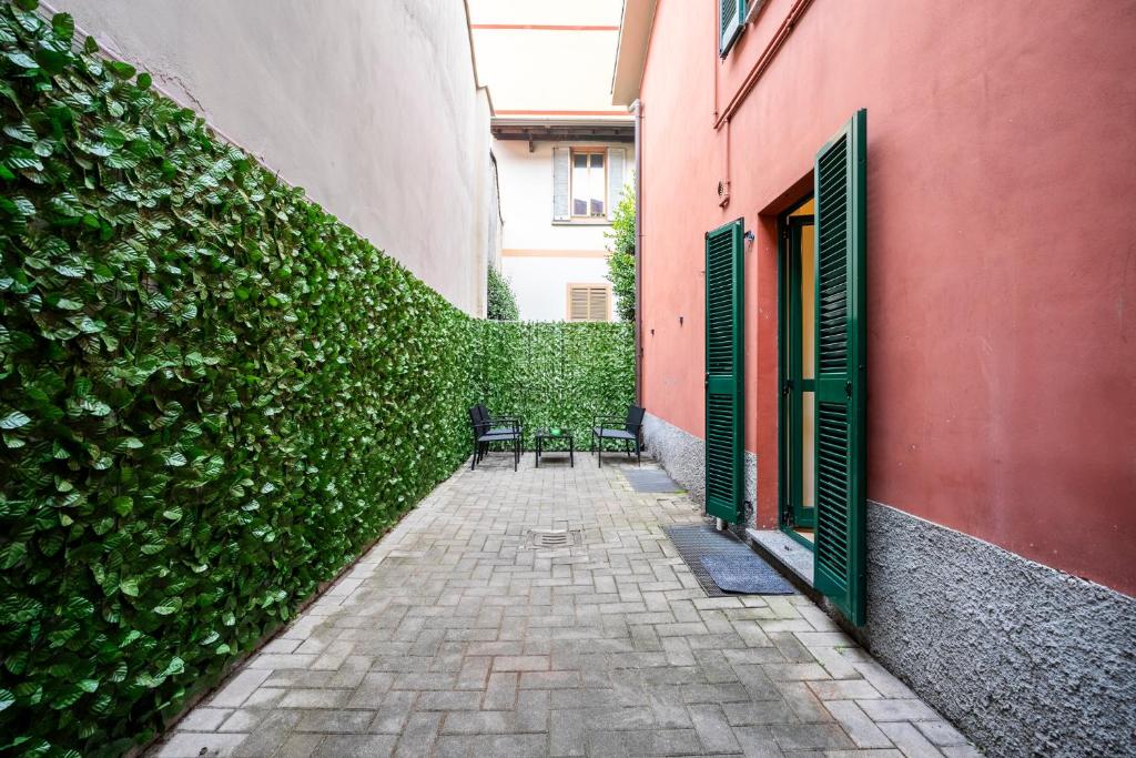 un vicolo con due sedie e un muro con piante di Giardino a Milano - Elegante Appartamento a Milano