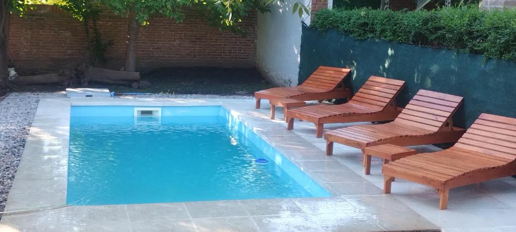 eine Gruppe von Stühlen und ein Swimmingpool in der Unterkunft Cabañas Don Pocho in Villa Cura Brochero