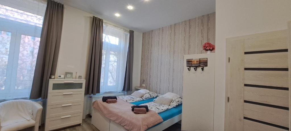 mała sypialnia z łóżkiem i oknem w obiekcie Pompár Belvárosi Apartman w Segedynie