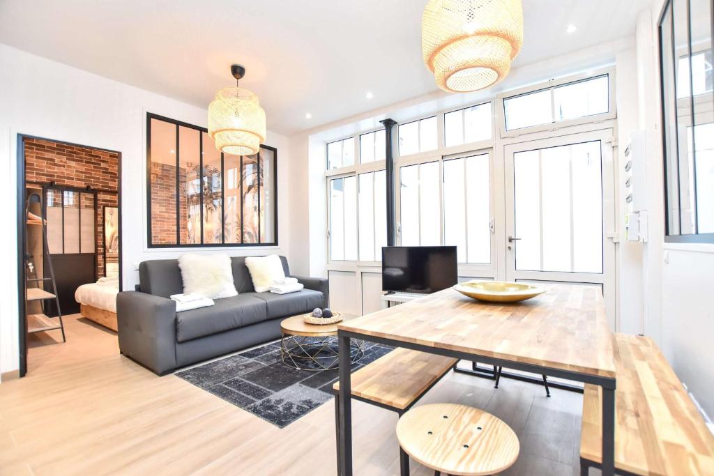 un salon avec un canapé et une table dans l'établissement Charmant appartement Paris, à Paris