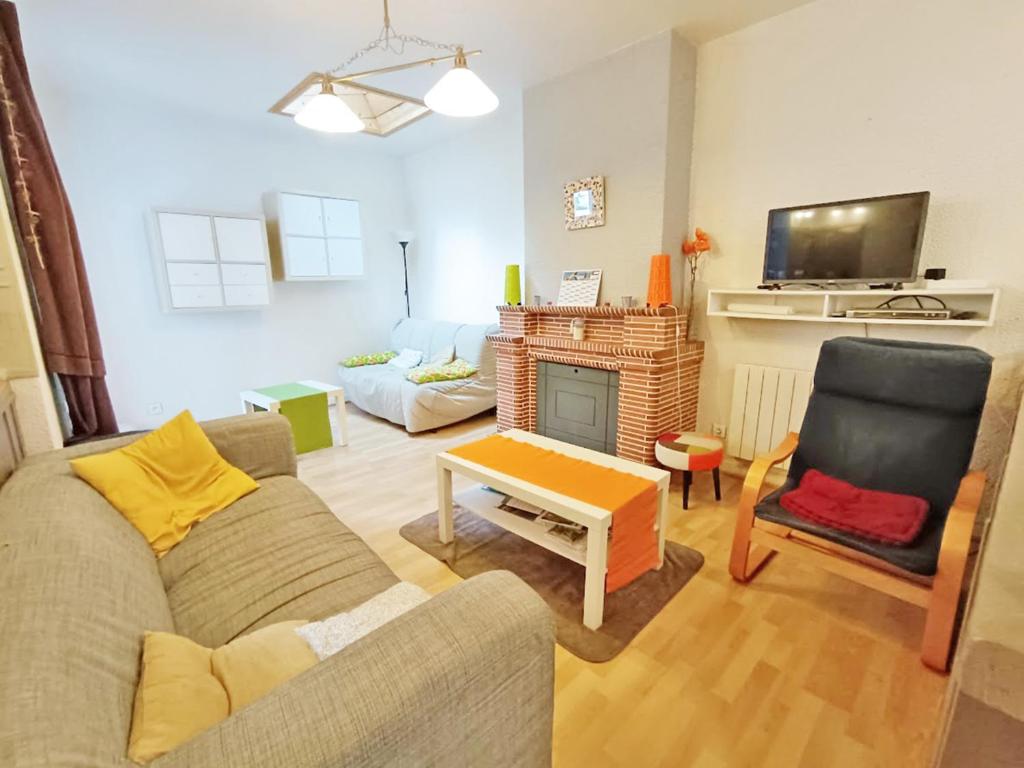 un salon avec un canapé et une cheminée dans l'établissement Les Estives, T2 bis, centre Luchon, wifi, 6 personnes, à Luchon