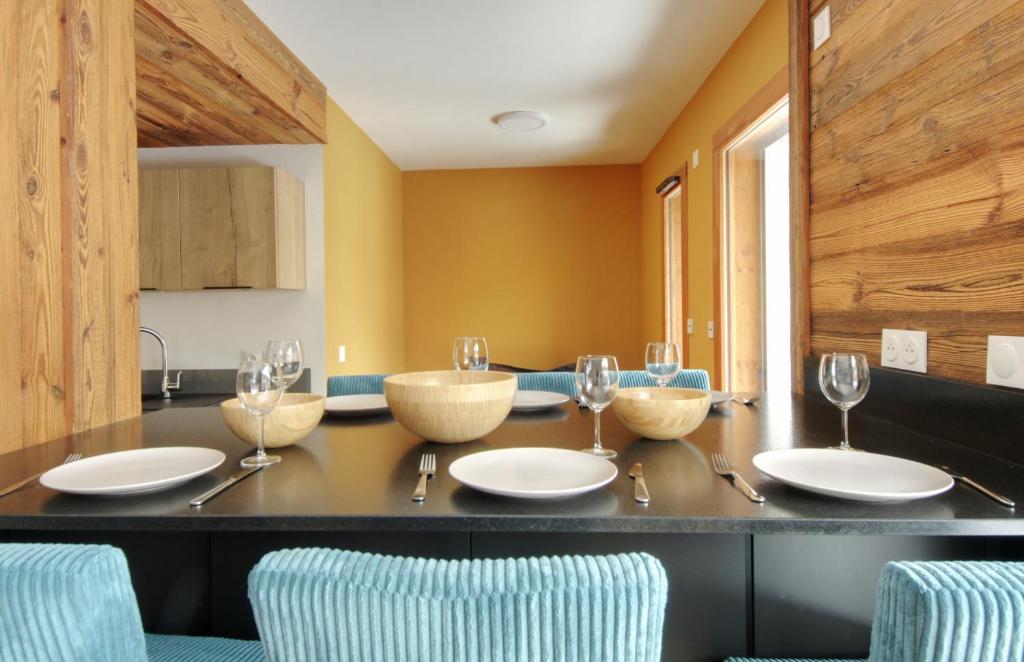 - une cuisine avec une table, des bols et des verres à vin dans l'établissement Apartment Altai Chamonix, à Chamonix-Mont-Blanc