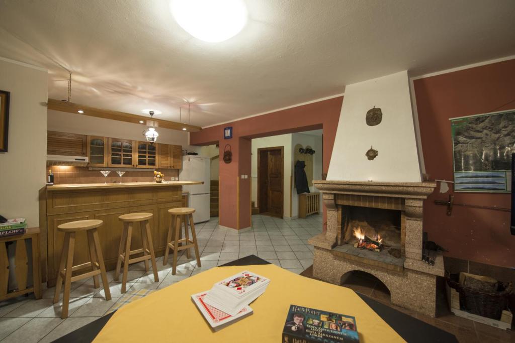 a living room with a fireplace and a kitchen at Chata Pleso in Tatranska Strba