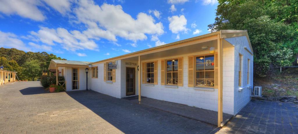 - un bâtiment blanc avec des fenêtres sur le côté dans l'établissement Port Arthur Motor Inn, à Port Arthur