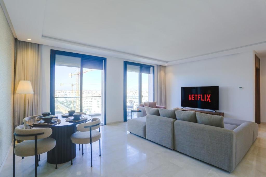 a living room with a couch and a table and chairs at Résidence Tour 33 - CFC district in Casablanca