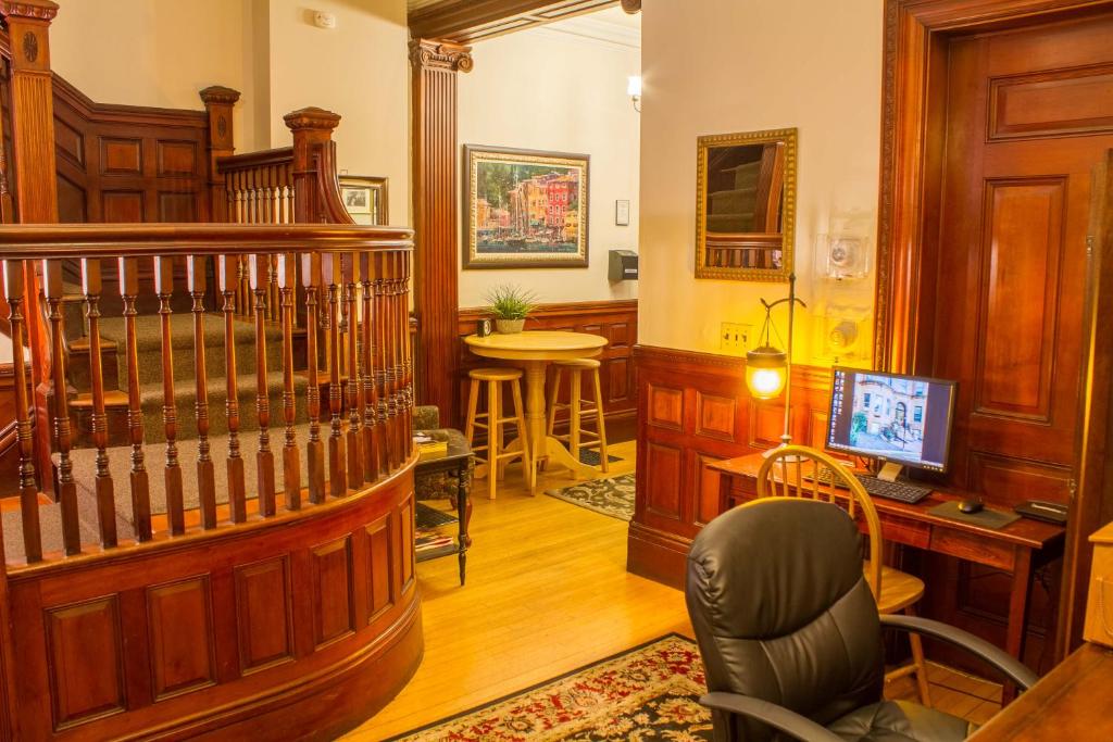 a living room with a staircase and a desk at Beacon Inn 1087 in Brookline