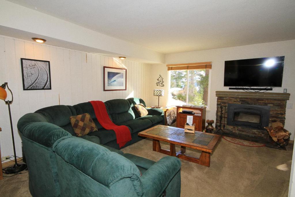 sala de estar con sofá verde y chimenea en Discovery 4 #115, en Mammoth Lakes