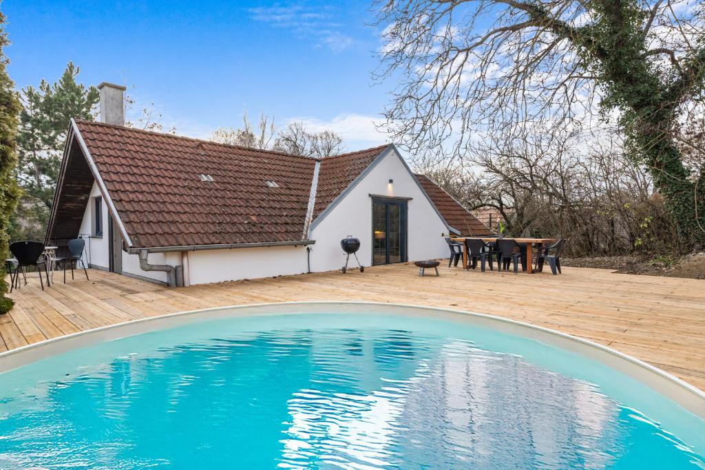 a house with a large swimming pool in front of it at Press4Living Cottage near Vienna in Ebenthal