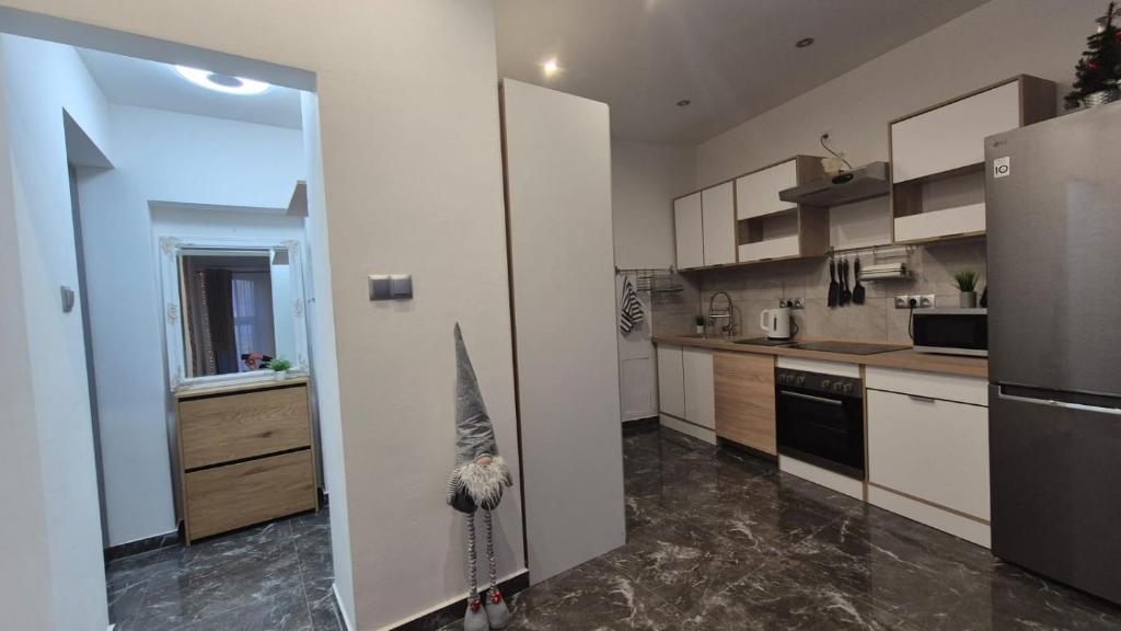 a kitchen with white cabinets and a stainless steel refrigerator at Studio u Arka in Kłodzko