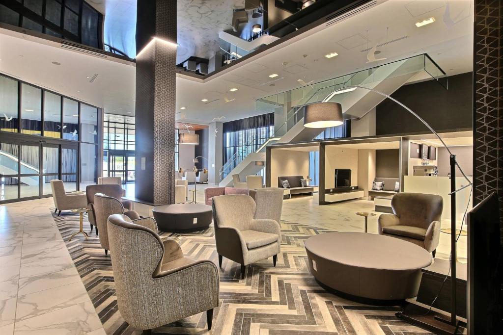 Un vestíbulo con sillas y una mesa en un edificio. en Courtyard by Marriott Montreal Brossard, en Brossard