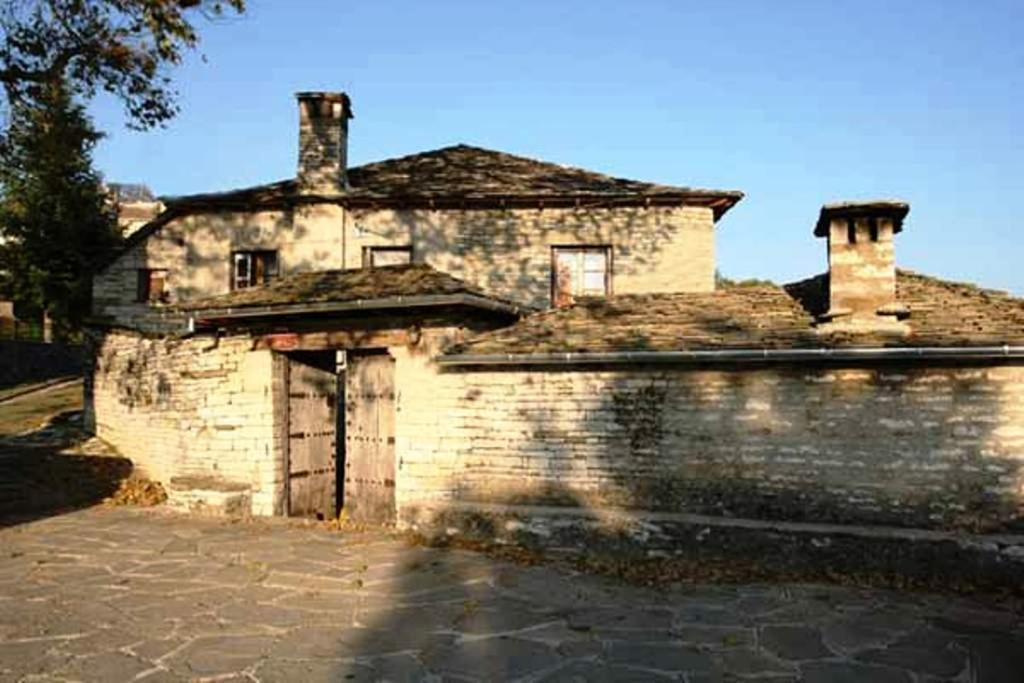 une ancienne maison en pierre avec un mur en briques dans l'établissement Archontiko Tzoufi, à Kapesovo