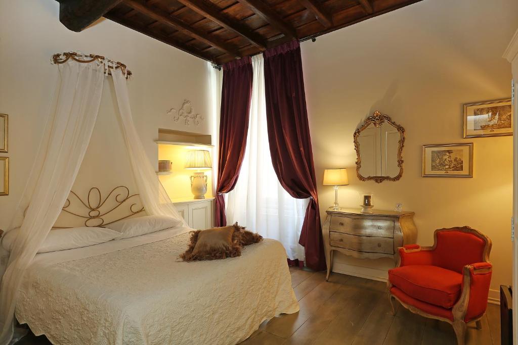 1 dormitorio con 1 cama, 1 silla y 1 ventana en Piazzetta de' Monti Suites, en Roma